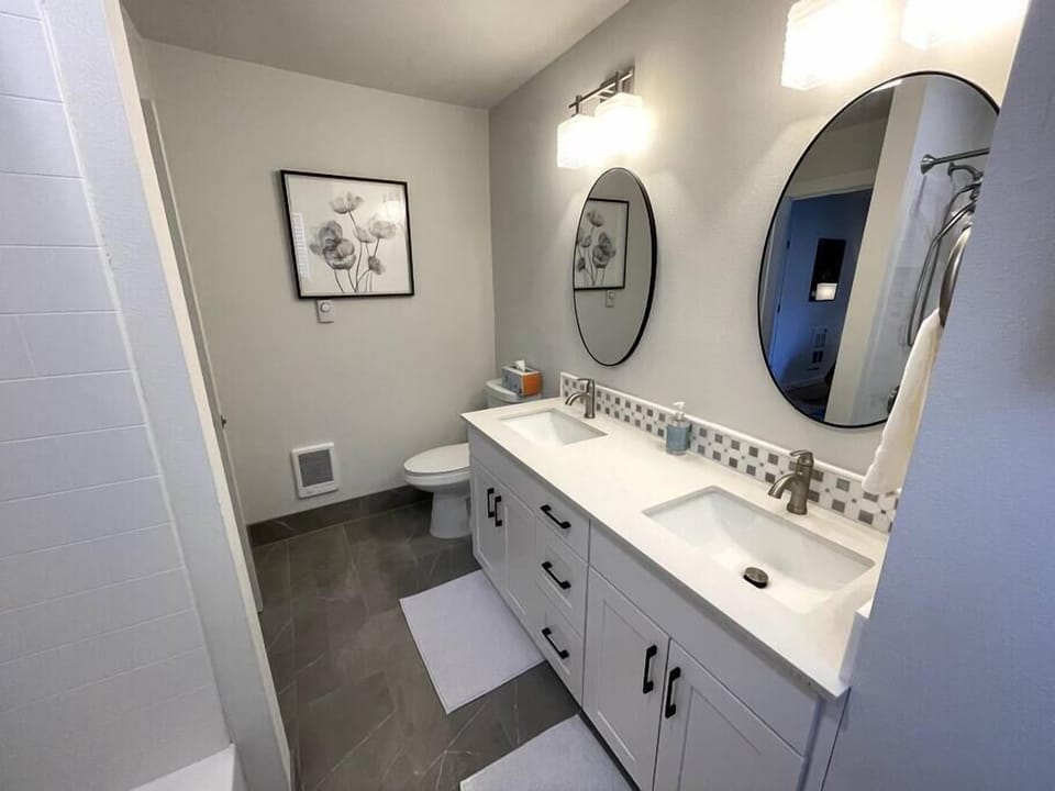 Primary bathroom with two sinks and a tub shower combo.