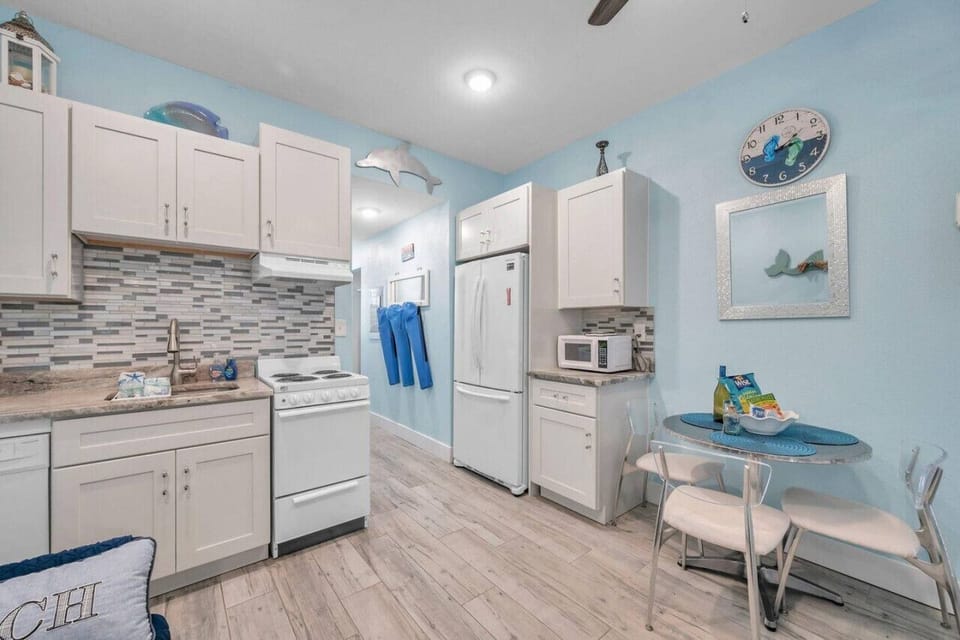 Clean, airy kitchen w/ plenty of cabinets & a cheerful coastal vibe.