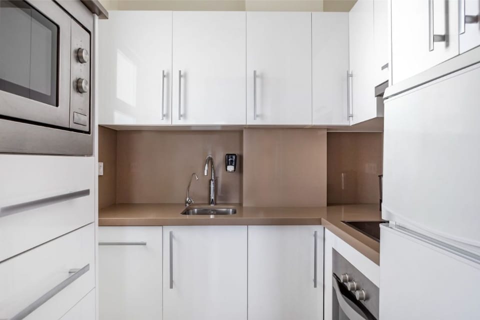 Sleek and modern kitchen, fully equipped with stainless steel appliances for a seamless cooking experience.