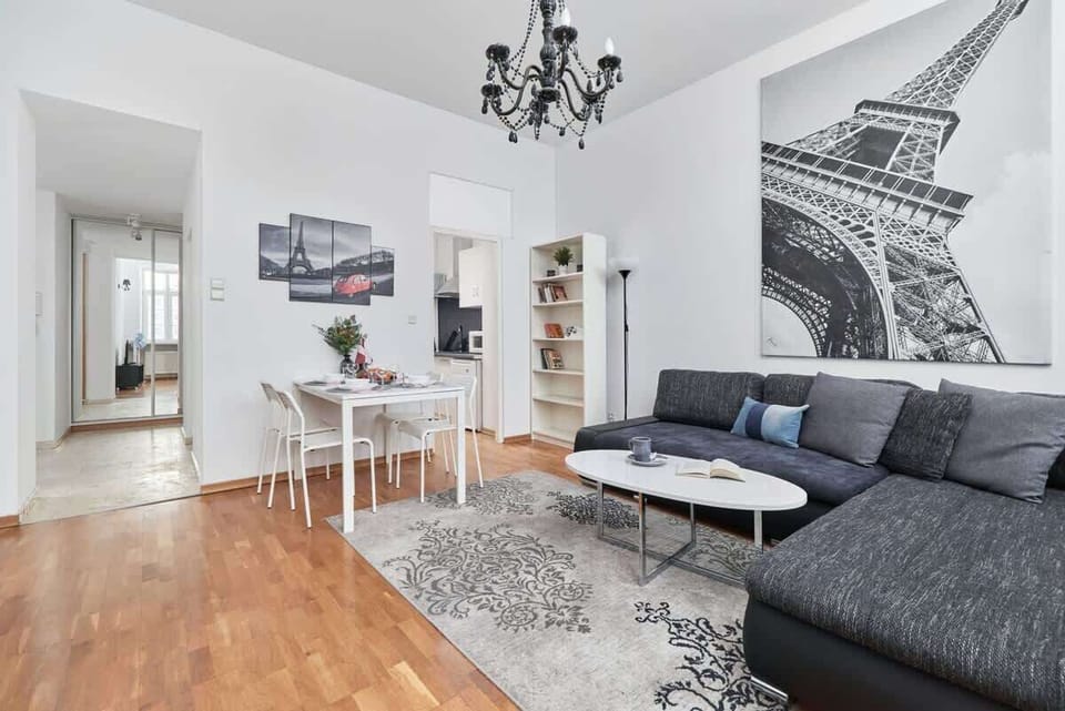 A cozy and elegant living area with a comfortable sofa, a modern coffee table, and stylish decor on the wall.