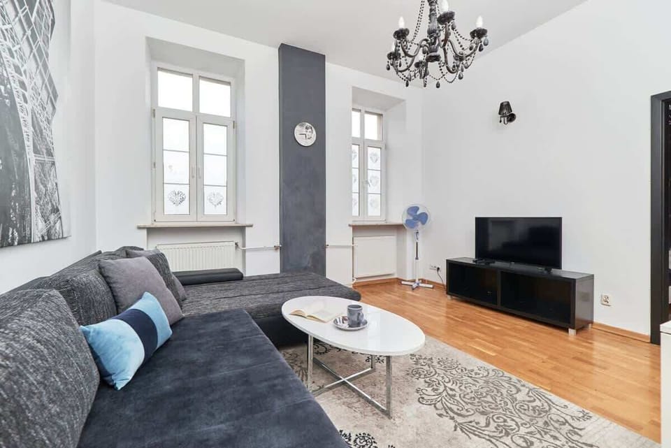 A cozy and elegant living area with a comfortable sofa, a modern coffee table, and stylish decor on the wall.