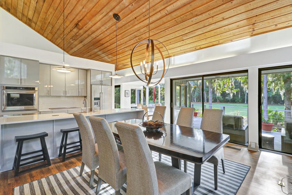 The dining area features a table for 6 and additional island seating for 4.