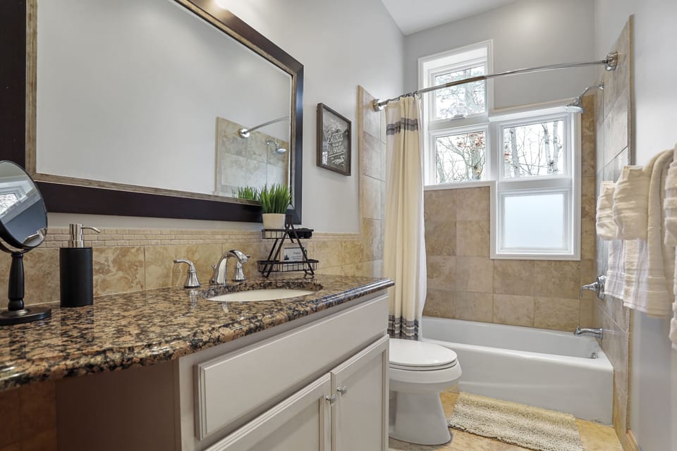 This main level full bath is bright and spacious for guests to share. 