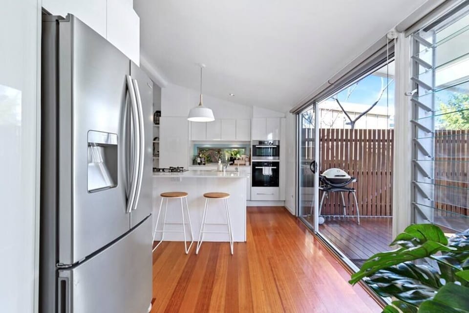 Open plan kitchen with Miele oven and microwave, refrigerator.