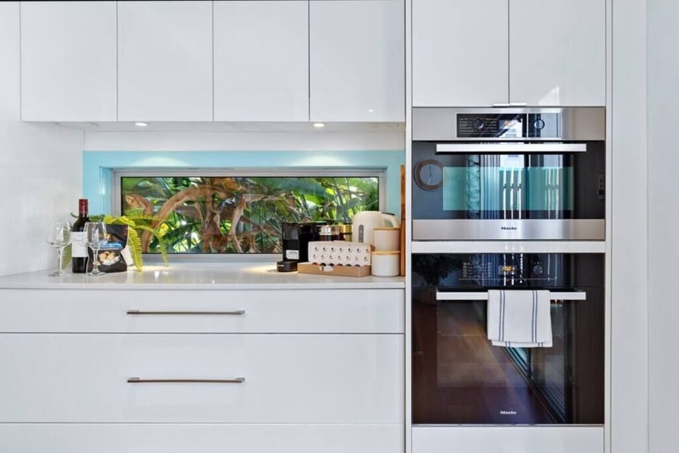 Open plan kitchen with Miele oven and microwave, refrigerator.
