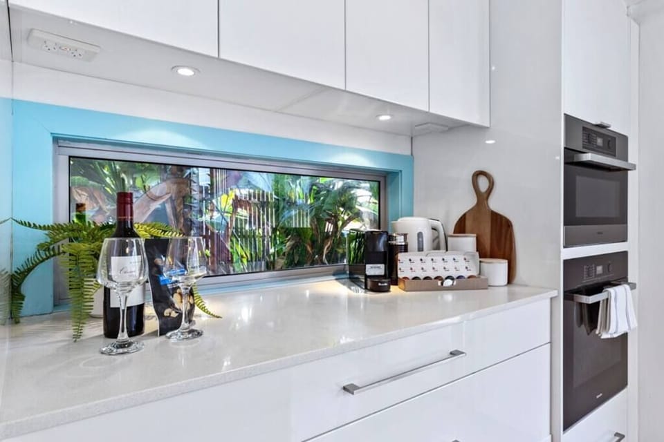 Open plan kitchen with Miele oven and microwave, refrigerator.