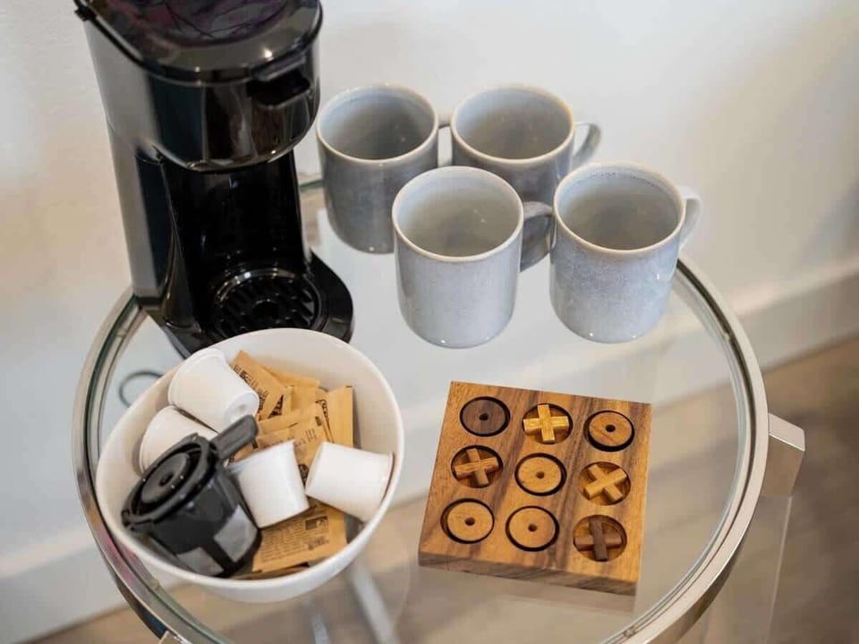 Start your day at the coffee bar: Keurig, mugs & a tic‑tac‑toe game for a playful touch.