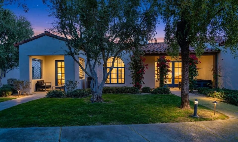 Spanish-style retreat with glowing windows, lit paths and patio nooks