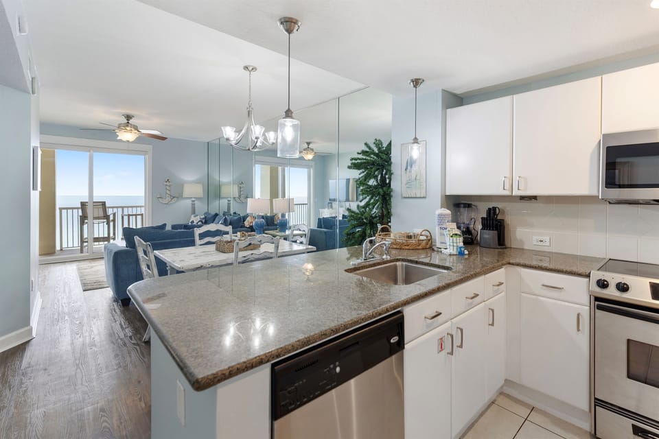 Your fully equipped kitchen flows into the open living space where ocean views greet you through floor-to-ceiling windows.