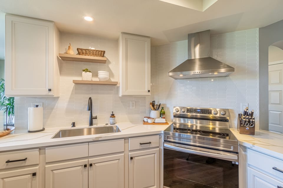 Kitchen with floating shelves and stainless appliances