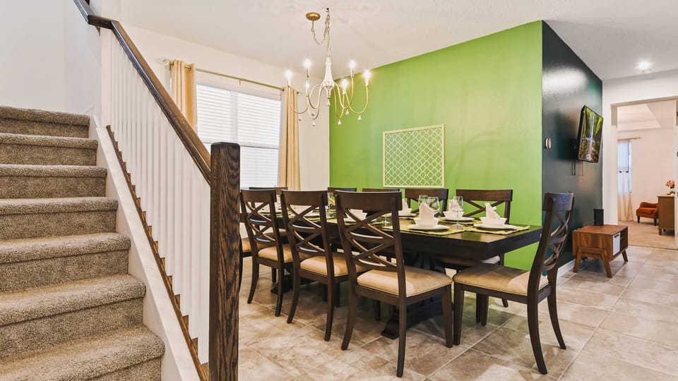 Elegant dining room with seating for eight, warm lighting, and a fresh green accent.