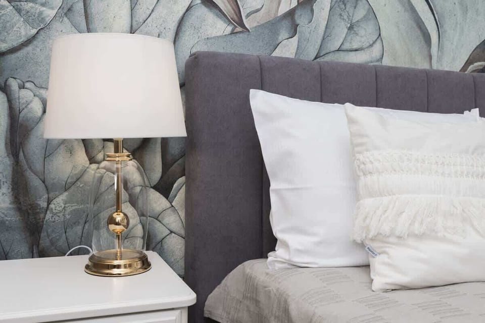 Close-up of a nightstand with elegant lamp and decorative details.
