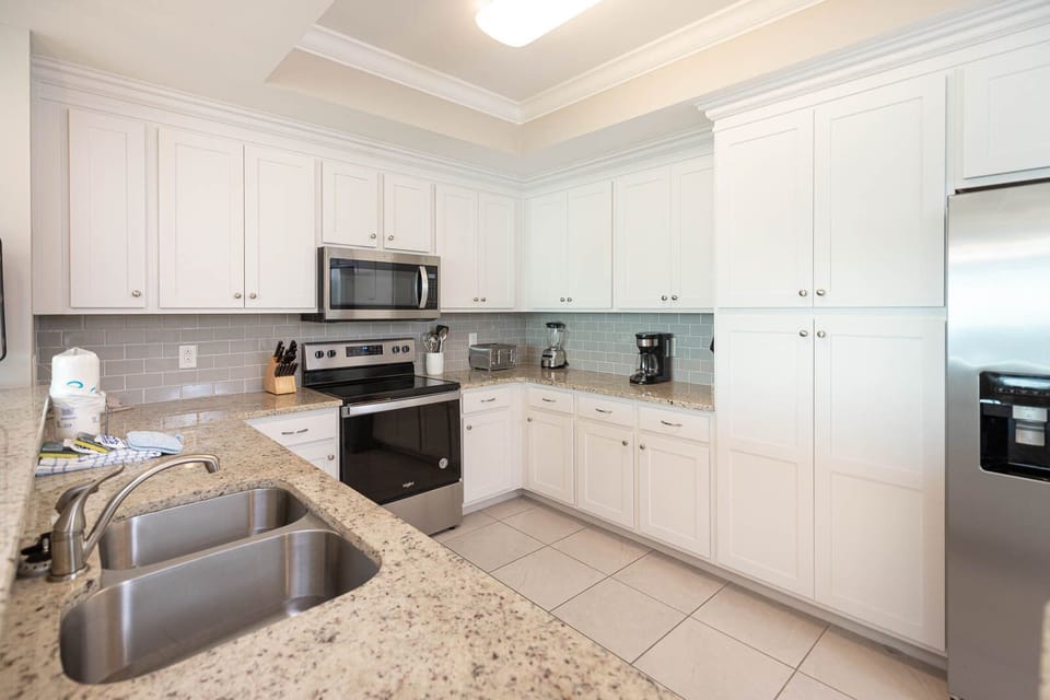 Craft delicious meals while enjoying the sleek countertops and inviting layout of this fabulous kitchen