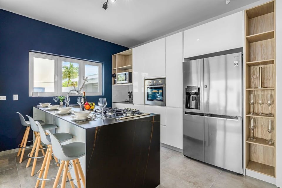 A fully equipped kitchen with a microwave, stove, oven fridge, and kitchen counter.