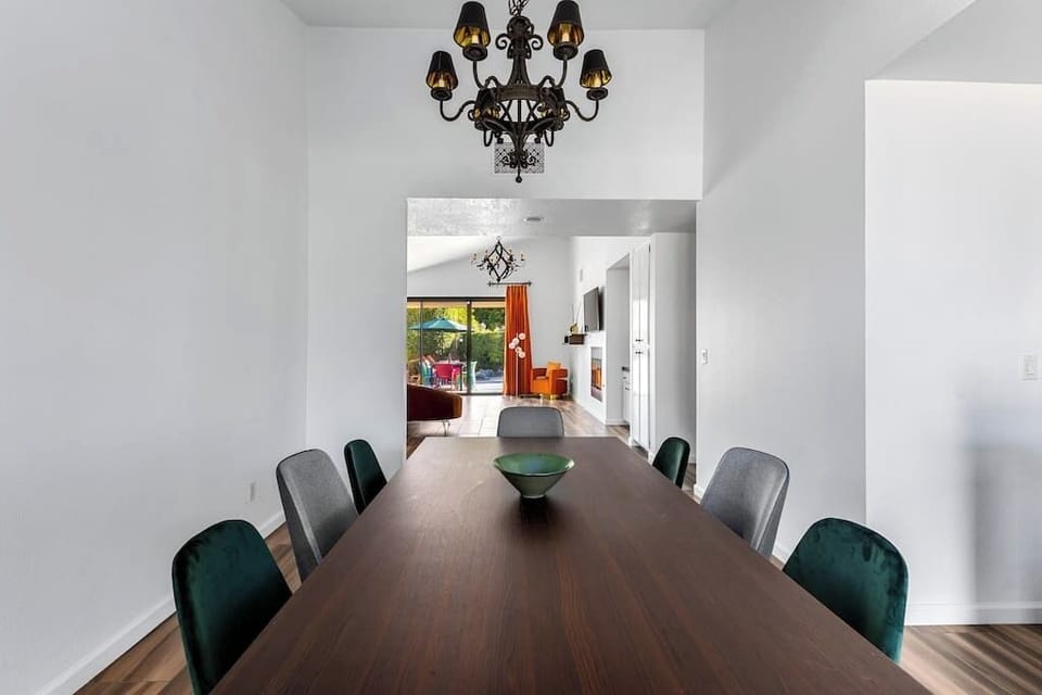 Bright dining room - long walnut table seats 8, wrought-iron chandelier, sliding doors open straight to the backyard