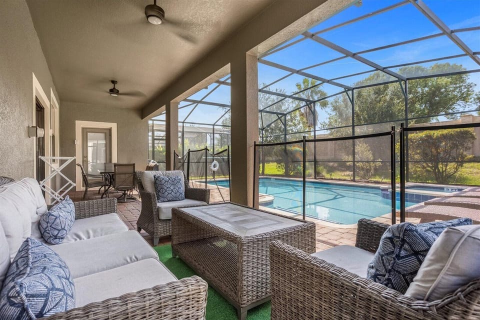 Covered Lanai with pool safety fence, pool door alarms, and plenty of seating
