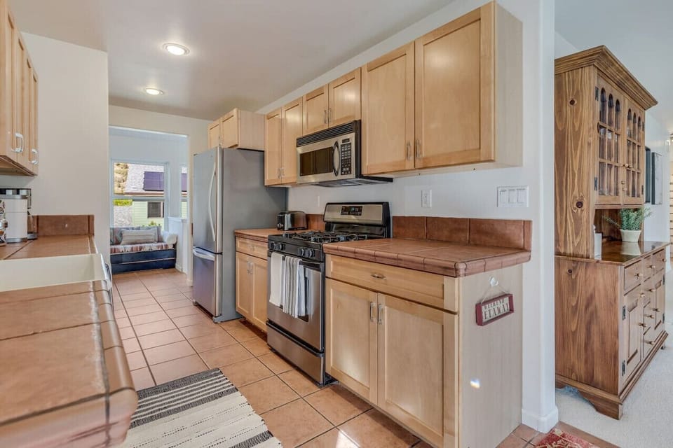 Kitchen with gas stove, oven, overhead microwave,  large fridge, lots of cabinets and counter space.