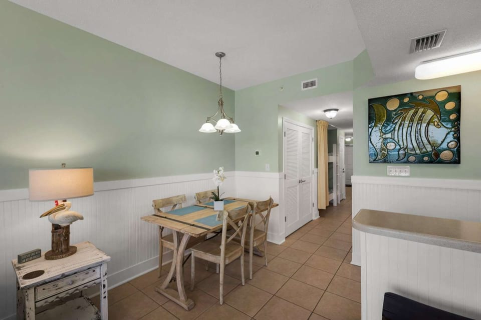 Cozy dining area with rustic wooden chairs and soft green walls for a relaxing meal.