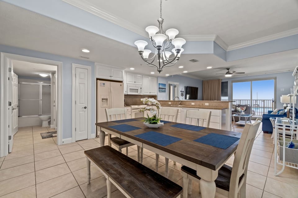 Open dining area with seating and a view into the living room and balcony.