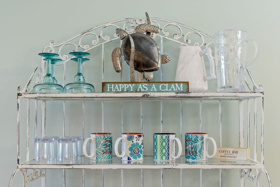Your cheerful coffee station awaits, stocked with colorful mugs and glassware to start each morning with coastal charm and a smile.