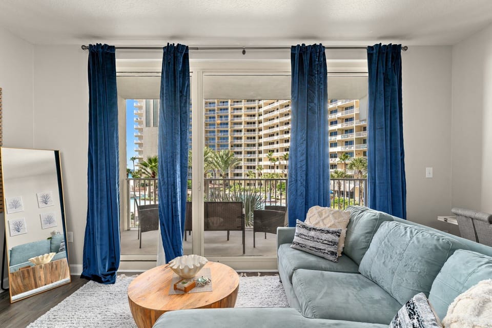 Compact room featuring a wall-mounted television and natural light from a window with blinds.