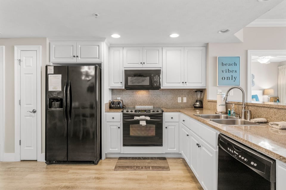 Modern kitchen with black appliances and white cabinetry for a clean look