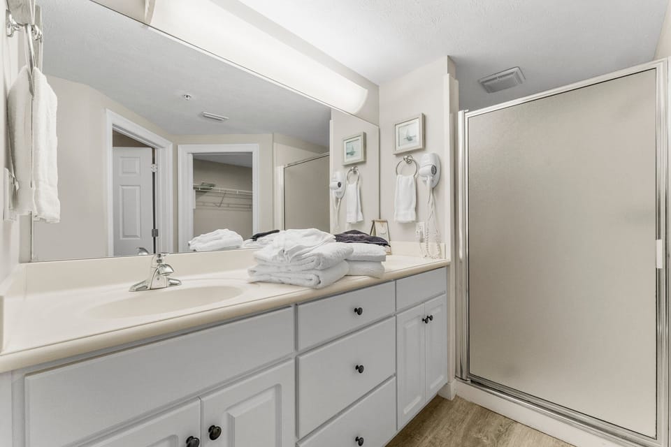 Clean bathroom with a large mirror and walk-in shower
