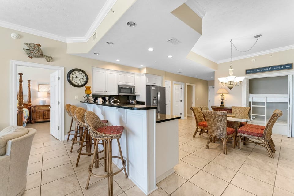 Open kitchen and dining area with modern appliances and seating for six.
