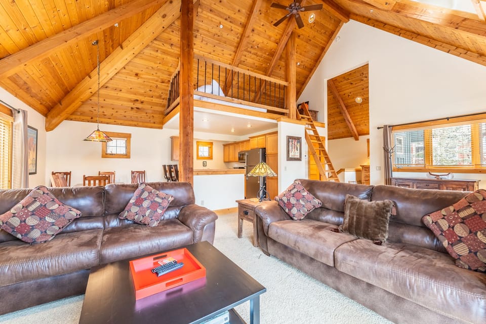 The living area offers cozy furnishings, vaulted ceilings, and a gas fireplace.