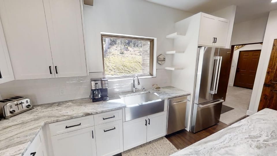 Step into your fully equipped kitchen with modern stainless appliances, elegant countertops, and a bright window for natural light while you cook your favorite meals.