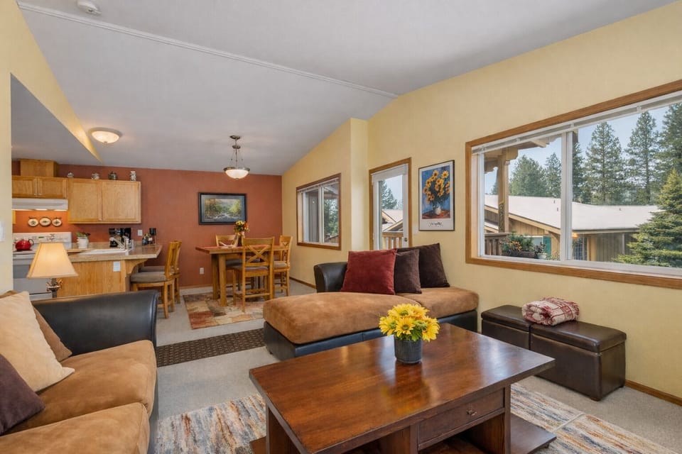 Unwind in your cozy living space with warm wood accents and mountain views through large windows.