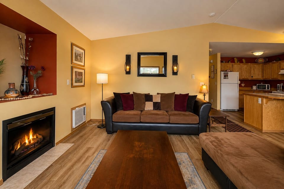 Living Room with sectional, gas fireplace, in wall AC unit, and TV with Streaming Apps.