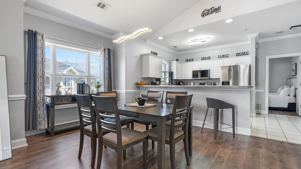 Bright dining area with seating for six and an open view into the kitchen.