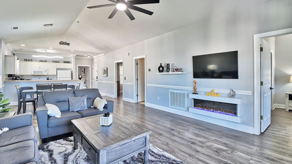 Spacious open-concept living and dining area with fireplace and vaulted ceiling.
