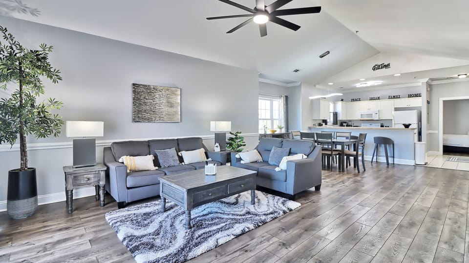 Open-concept living, dining, and kitchen area with vaulted ceilings.