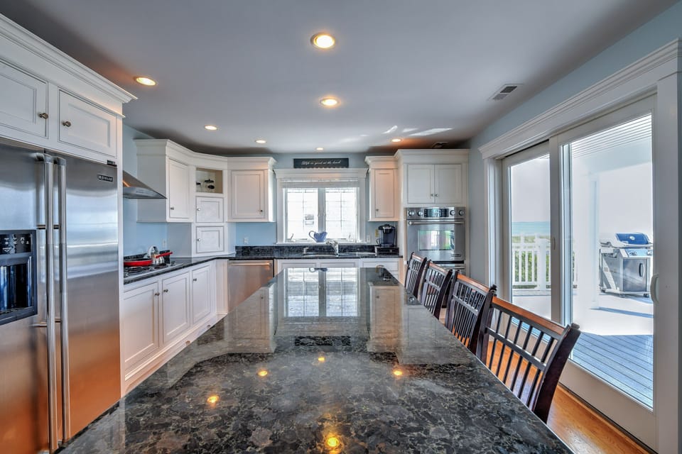 Updated white kitchen with stainless steel appliances.