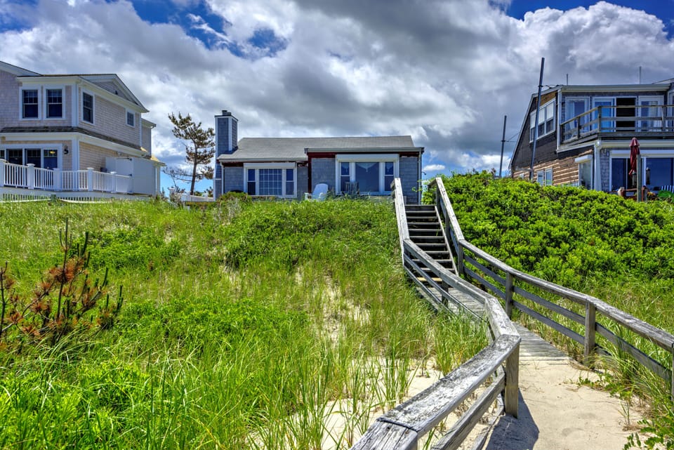 Back of the home with private boardwalk to the beach.