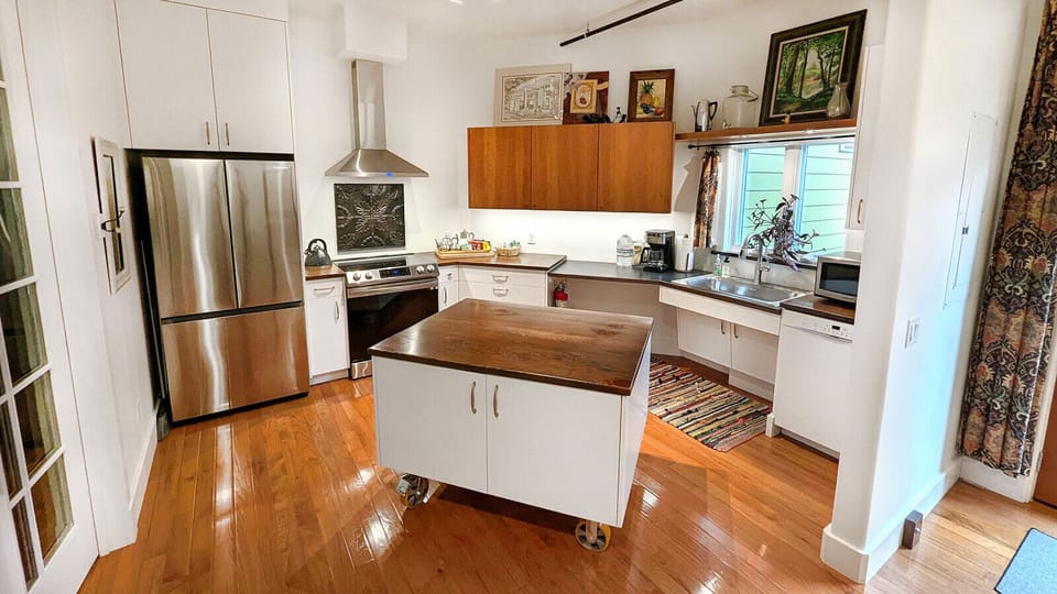 The Kitchen is open to the front Office-Living Room. There is a 5` turning space in front of the refrigerator and plenty of space at the sink for a chair. The Island locks into place, but can be unlocked & moved if more space is needed at the sink.