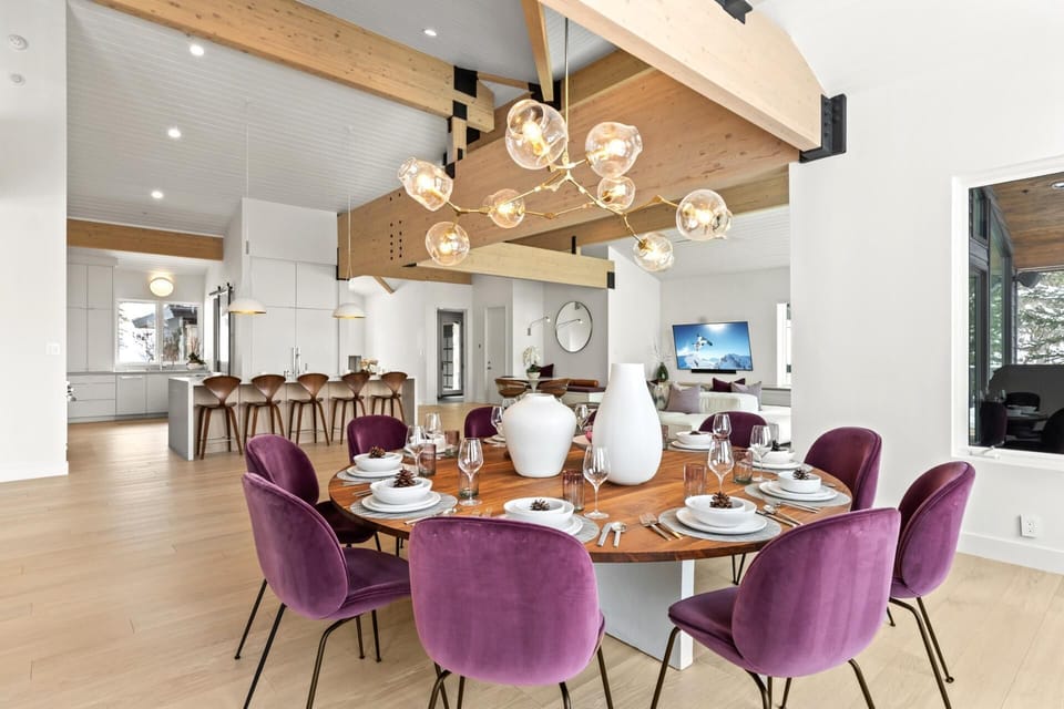     Open-concept luxury: modern dining, sleek kitchen, warm natural lighting.