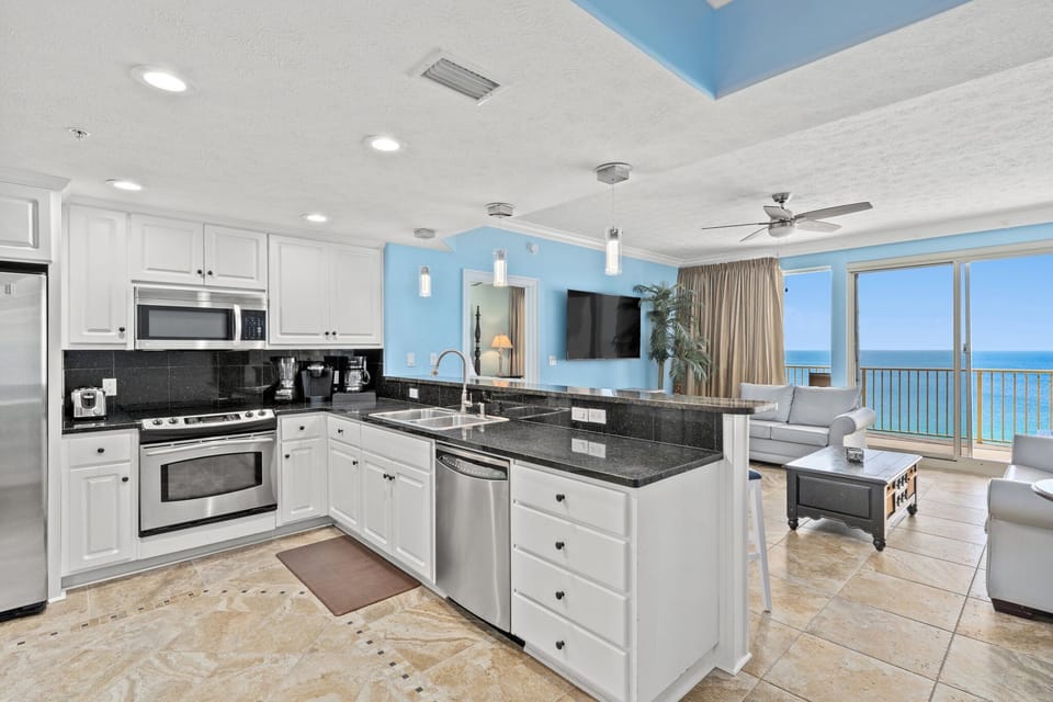 Modern kitchen with stainless steel appliances and ocean views from the living area.
