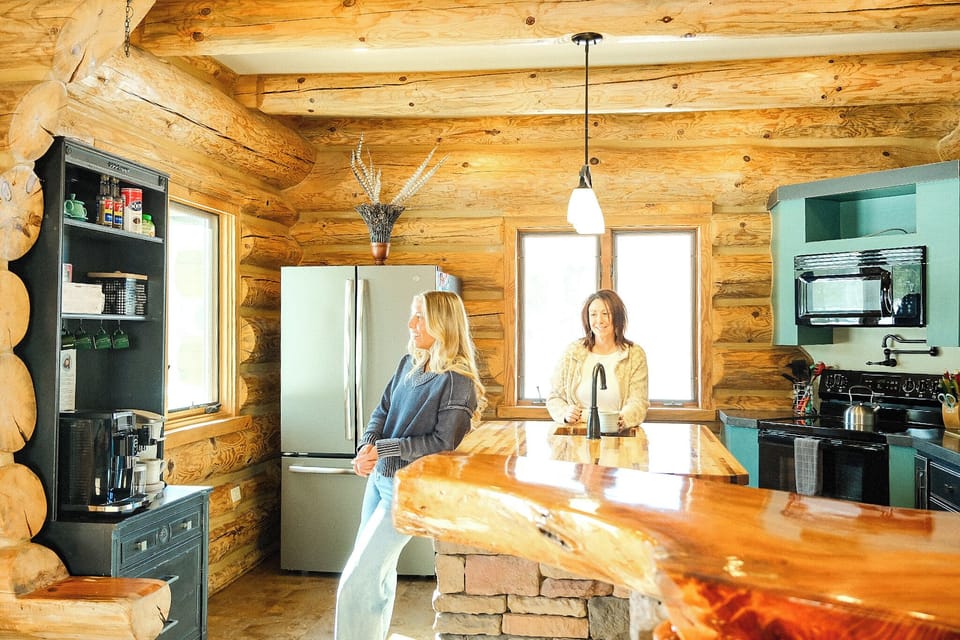 Rustic log cabin kitchen with live-edge bar and bright modern touches