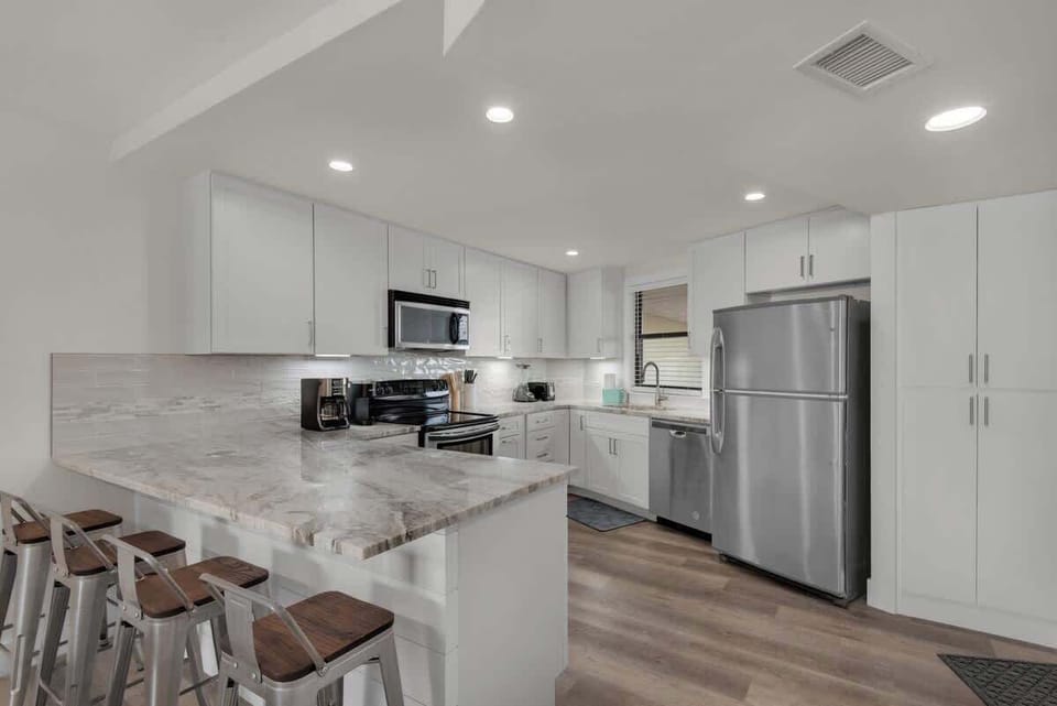 The Newly Remodeled White Kitchen features Beautiful Countertops and Stainless Steel Appliances.