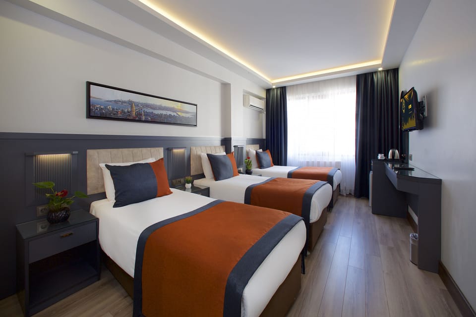 Standard Triple Room | Minibar, in-room safe, desk, laptop workspace
