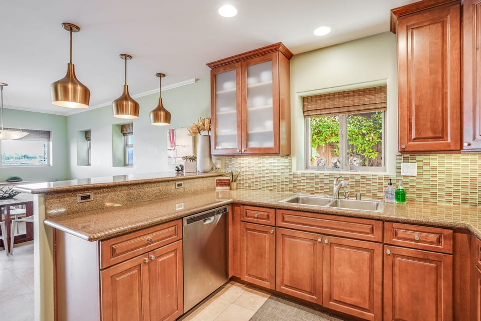 A sleek, contemporary kitchen with marble countertops and premium stainless steel appliances.