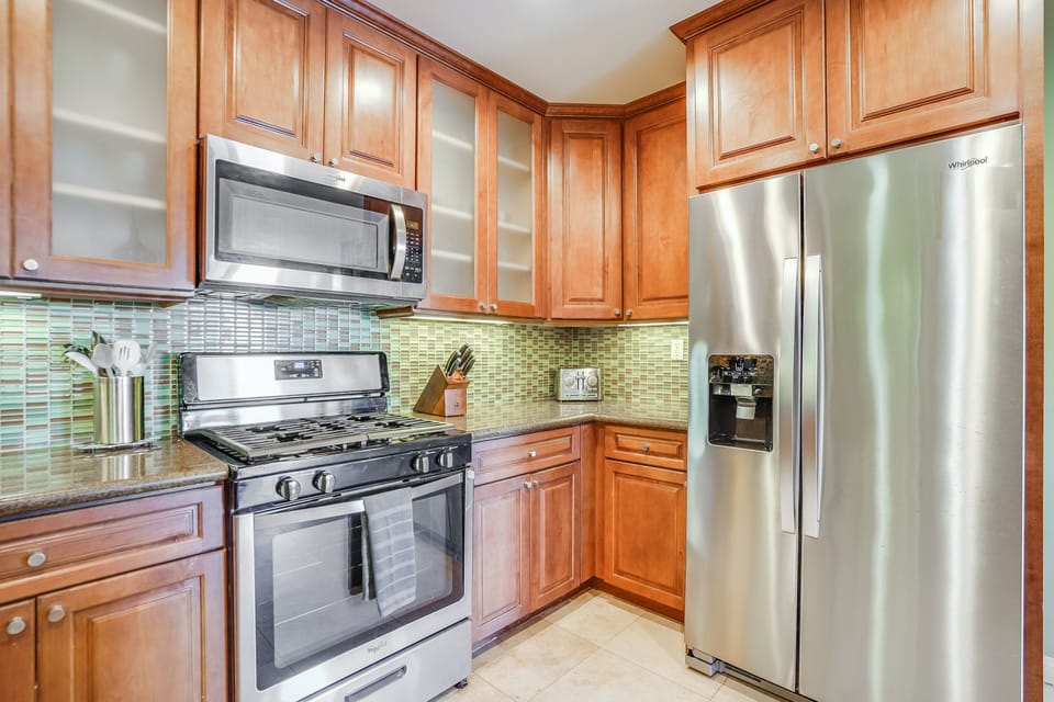 This kitchen is equipped with a spacious premium fridge-freezer and quality cooking utensils