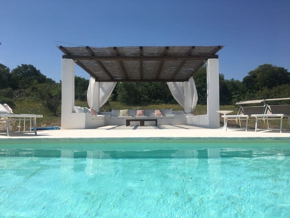Pool area with sun-loungers and couches to enjoy lazy days by the pool