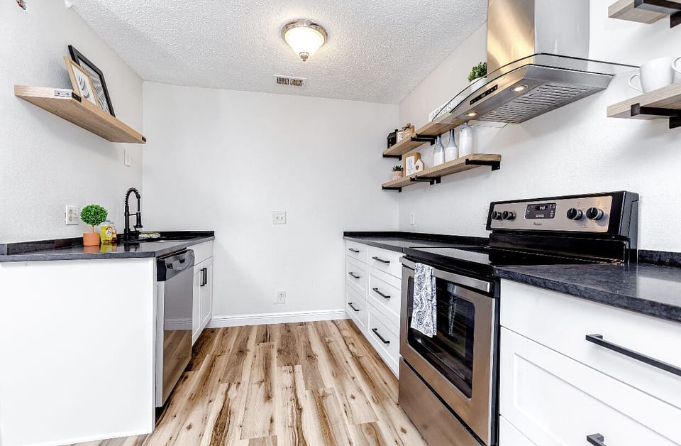 Remodeled space with modern kitchen and stainless steel appliances.