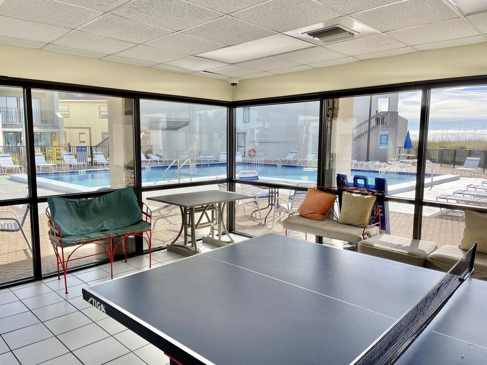 Amenity building with shaded seating, ping-pong, and games.