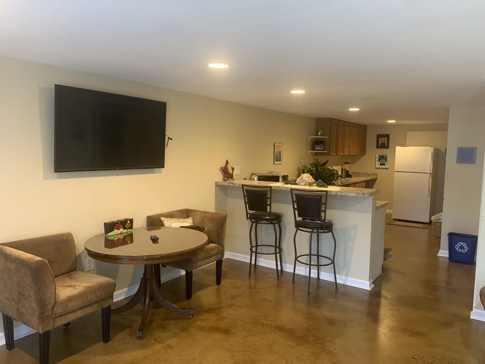 Large open den area featuring vintage dining room table and brand new couch.