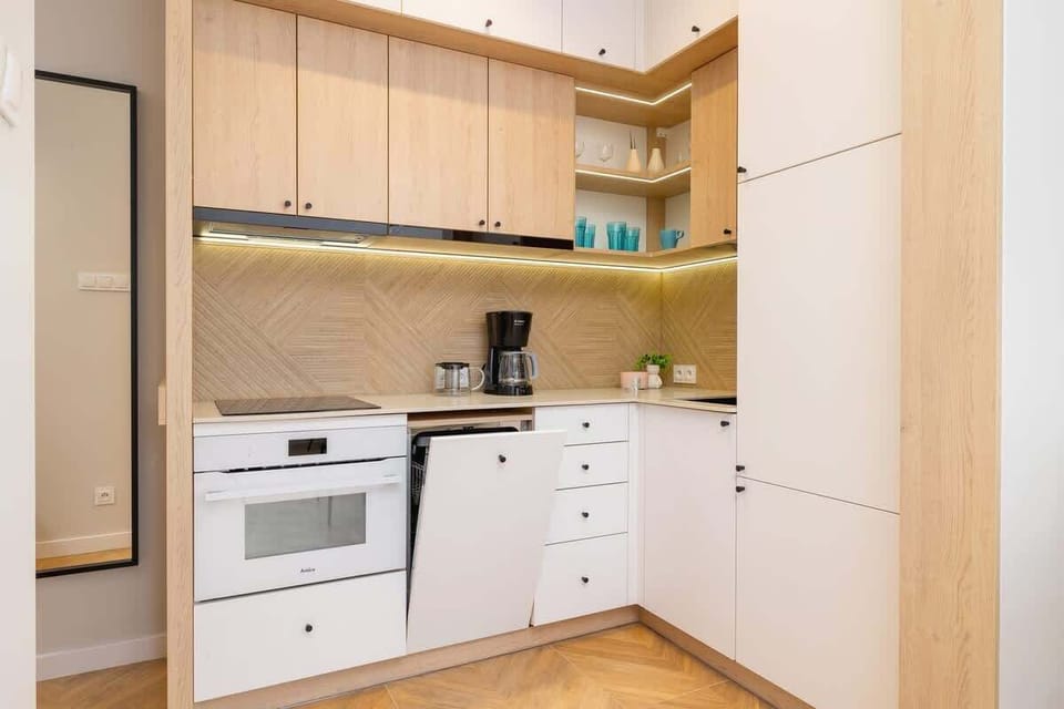A functional kitchen with light wood cabinetry, built-in appliances, and modern decor, offering a clean and practical cooking area.
